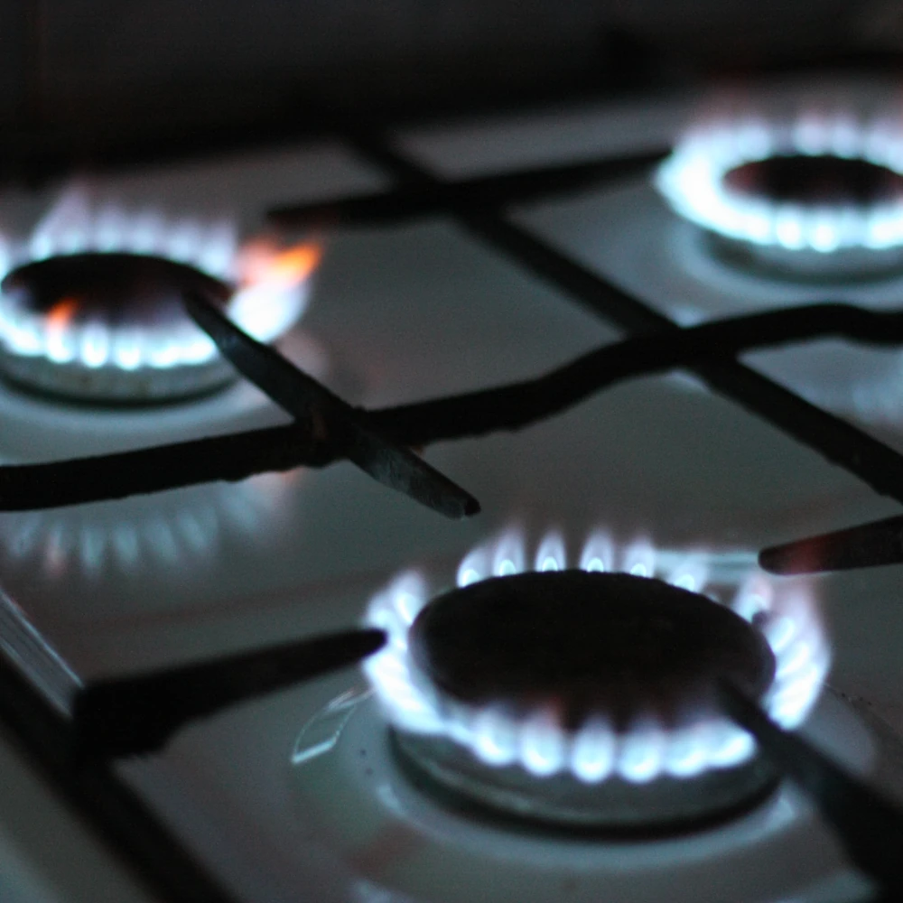 A lit gas stove that represents the gas plumbing services